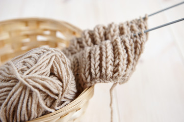 beige yarn for knitting in a straw basket close-up