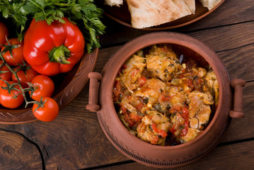 Chakhokhbili - Georgian traditional food. The dishes of Georgia,  chicken with tomatoes and herbs on a wooden background