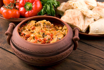 Chakhokhbili - Georgian traditional food. The dishes of Georgia,  chicken with tomatoes and herbs on a wooden background