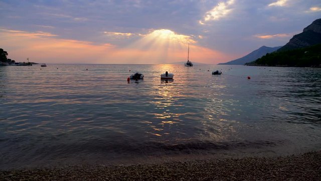The splash of waves under the rays of the setting sun on a quiet summer evening