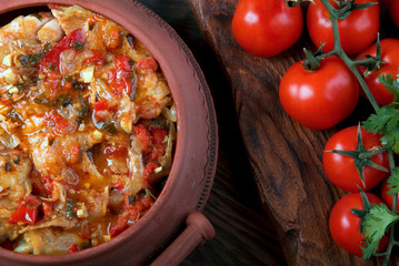 Chakhokhbili - Georgian traditional food. The dishes of Georgia,  chicken with tomatoes and herbs on a wooden background