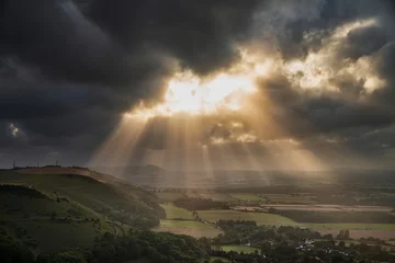 Türaufkleber Stunning Summer landscape image of escarpment with dramatic storm clouds and sun beams streaming down © veneratio