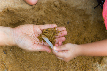 Lifestyle portrait mom son and daughter  playing with sand, Funny Asian family in a public  playground.