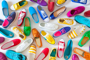 A lot of colored youth women's shoes without heels. Sneakers, slippers, ballet shoes. White background. - obrazy, fototapety, plakaty