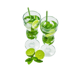 Two beautiful glasses with mojito and tubules. Isolated on white. Mint, rum, lime.