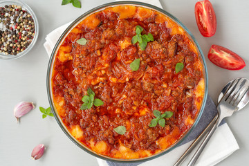 Meat casserole with potatoes, tomatoes and cheese.