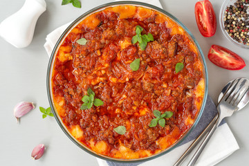Meat casserole with potatoes, tomatoes and cheese.