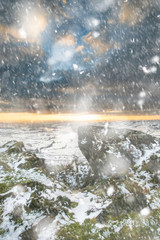 Stunning Winter sunset over snow covered Winter landscape in Peak District in heavy snow storm