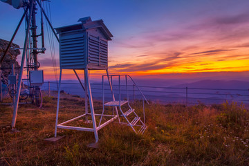 Fototapeta na wymiar weather station in sunset mountain landscape.