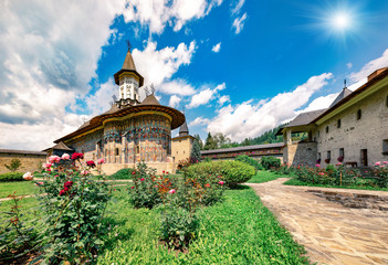 Fototapeta premium Bright summer scene of Sucevita Monastery. Picturesque morning view of Eastern Orthodox Church, built in 1585 by Ieremia Movila, Bukovina region, Romania, Europe.