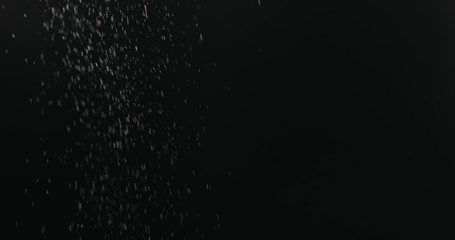 fine dust particles falling on black background