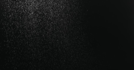 fine dust particles falling on black background