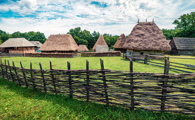 Fototapeta na wymiar Stunning summer view of traditional romanian peasant houses. Bright rural scene of Transylvania, Romania, Europe. Beauty of countryside concept background.