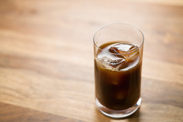 Glass of iced coffee on wooden table