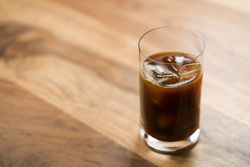 Glass of iced coffee on wooden table