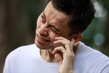 耳に痛みを感じる男性