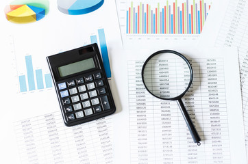 Single Magnifying Glass with calculator, Leaning on the financial data. Business and Finance...