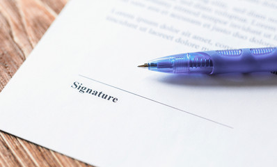 Close up of pen lying on a contract or application form to sign