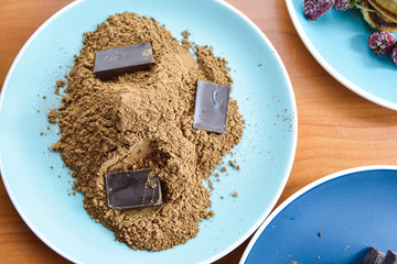grated chocolate with chocolate bars on a blue plate