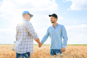 Male farmers shaking hands in wheat field © Pixel-Shot