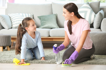 Little girl and her mother cleaning flat