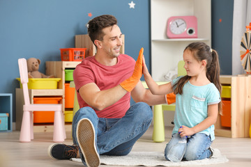 Father and daughter giving each other high-five after cleaning flat