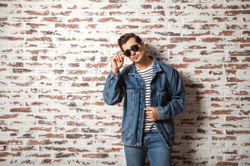 Stylish fashionable man near brick wall