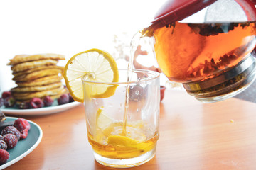 tea with lemon in a transparent mug and a white background