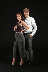 Fototapeta premium Portrait of fashionable young couple on dark background