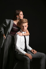 Portrait of fashionable young couple on dark background