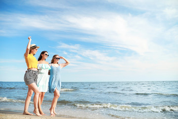 Fototapeta na wymiar Happy young women on sea beach at resort