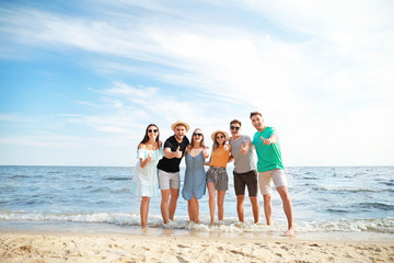 Happy friends on sea beach at resort