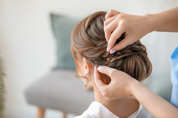 Naklejka premium Professional hairdresser working with young bride at home