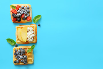 Tasty sweet waffles on color background