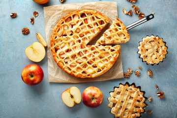 Tasty apple pies on color background