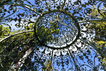 Wrought iron gazebo dome roof in the park on a sunny day
