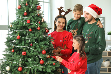 Happy family decorating Christmas tree at home