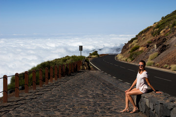 young woman on the road above the clouds - 291248106