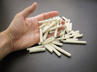 Kashk dried whey cured qurt. Kashk, dried whey or curd. Kashk also called qurt, kurut, gurt or qurut drained yougurt on hand with dark background. Traditional Iranian dairy products.