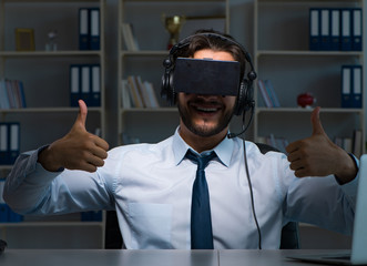 Fototapeta premium Businessman gamer staying late to play games