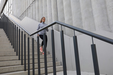 Runner athlete running on stairs. Woman fitness is jogging oudoors