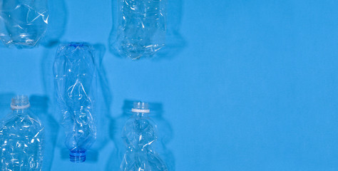 Plastic bottles isolated on blue background. Seamless pattern. Recycle waste management concept. Plastic Pet Bottles. Copy space