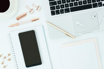Flat lay mockup Female Office desktop with laptop, coffee cup, earphones, blank notepad and mobile...