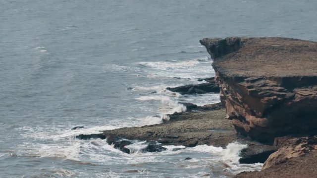 Sea waves besides the cliff in Diu, India