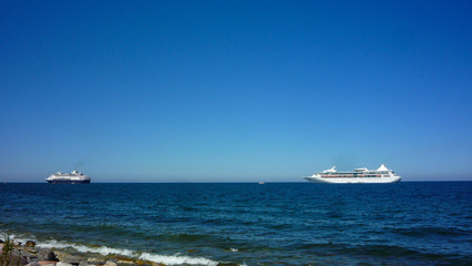 Holland America Line Ryndam and Royal Caribbean Vision of the Seas at sea with blue sky in summer...