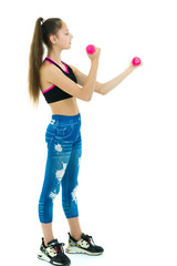 Teenage girl with dumbbells in hands