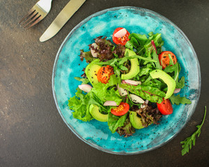 healthy salad avocado, vegetables, mix leaves, salad dressing (tasty and healthy food) menu concept. food background. copy space. Top view
