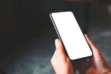 Mockup image of hands holding black mobile phone with blank desktop screen