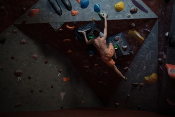 Athletic man practicing in a bouldering gym