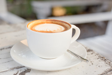 A cup of a coffee in white glass on white table